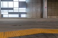 the yellow safety mat is on a brick walkway with windows and a door way to it