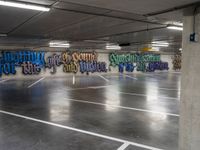 an empty parking garage with colorful graffiti on it's walls and floor, as well as the words