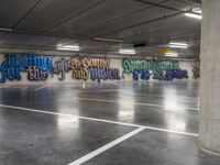 an empty parking garage with colorful graffiti on it's walls and floor, as well as the words