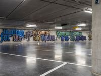 an empty parking garage with colorful graffiti on it's walls and floor, as well as the words