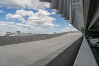 a parking garage with lots of parked vehicles in it and overhangs that allow access to the highway