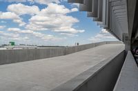 a parking garage with lots of parked vehicles in it and overhangs that allow access to the highway