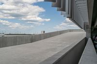 a parking garage with lots of parked vehicles in it and overhangs that allow access to the highway