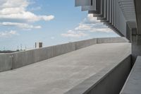 a parking garage with lots of parked vehicles in it and overhangs that allow access to the highway