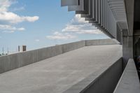 a parking garage with lots of parked vehicles in it and overhangs that allow access to the highway