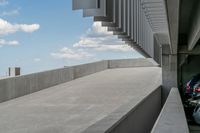 a parking garage with lots of parked vehicles in it and overhangs that allow access to the highway