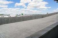 a parking garage with lots of parked vehicles in it and overhangs that allow access to the highway