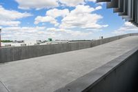 a parking garage with lots of parked vehicles in it and overhangs that allow access to the highway