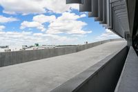 a parking garage with lots of parked vehicles in it and overhangs that allow access to the highway