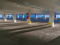 a empty parking garage with red and yellow signposts on the right floor of the room