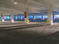 a empty parking garage with red and yellow signposts on the right floor of the room