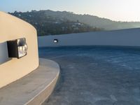 this concrete wall with a mirror is an amazing feature in this image, and the circular pool is almost empty