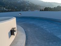 this concrete wall with a mirror is an amazing feature in this image, and the circular pool is almost empty