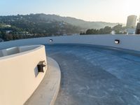 this concrete wall with a mirror is an amazing feature in this image, and the circular pool is almost empty