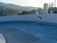 this concrete wall with a mirror is an amazing feature in this image, and the circular pool is almost empty