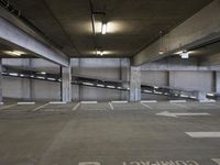 a parking garage with parking spaces marked in white on the floor area where the cars are parked