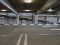 a parking garage with parking spaces marked in white on the floor area where the cars are parked