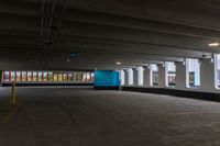 a parking garage with a blue door and white walls, and two red cars parked under the area