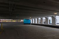 a parking garage with a blue door and white walls, and two red cars parked under the area