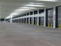 an empty parking garage with lots of doors opened up to let out passengers inside and outside