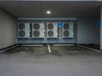 a parking lot with multiple rows of air conditioners and one unit without any windows