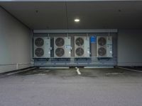 a parking lot with multiple rows of air conditioners and one unit without any windows