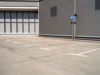 an empty parking lot with a closed space and several windows that are mostly open on the right side