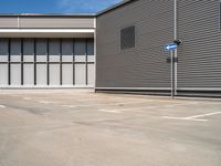 an empty parking lot with a closed space and several windows that are mostly open on the right side