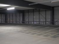 a parking garage is empty and has lights on the ceiling and inside of it are black walls and grey concrete