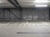 a parking garage is empty and has lights on the ceiling and inside of it are black walls and grey concrete