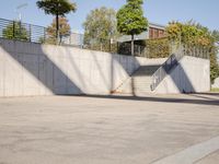 an empty parking lot with an outside stair way that leads to the bottom level and below a ramp