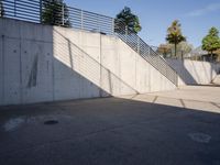 an empty parking lot with an outside stair way that leads to the bottom level and below a ramp