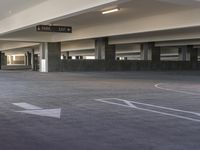 an empty parking lot in an empty building with parking spaces painted white on it's