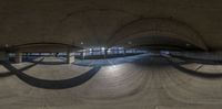 a skateboard ramp in a circular room next to an empty building by the water