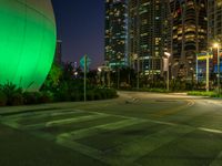 empty parking lot with buildings in the background and green lighting from street lamps at dusk