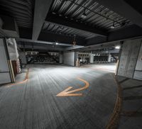 an empty parking garage has been decorated with orange arrows in it and the floor is dark