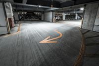 an empty parking garage has been decorated with orange arrows in it and the floor is dark