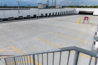 a parking lot is empty of cars and a no parking sign on the railing in front