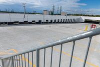 a parking lot is empty of cars and a no parking sign on the railing in front