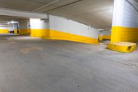 an empty parking garage with concrete floors and yellow painted accents painted in white and yellow