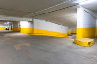 an empty parking garage with concrete floors and yellow painted accents painted in white and yellow