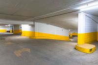 an empty parking garage with concrete floors and yellow painted accents painted in white and yellow