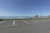 a large empty parking lot with sea and blue sky in the background in this view of the ocean