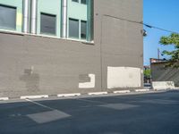 a paved street has been painted light gray, with gray brick walls and concrete edges