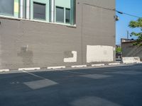 a paved street has been painted light gray, with gray brick walls and concrete edges