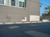 a paved street has been painted light gray, with gray brick walls and concrete edges