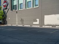 a paved street has been painted light gray, with gray brick walls and concrete edges