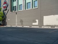 a paved street has been painted light gray, with gray brick walls and concrete edges