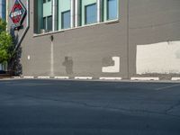 a paved street has been painted light gray, with gray brick walls and concrete edges