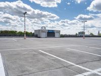 a parking lot with a store front and parking spaces in it on a partly cloudy day